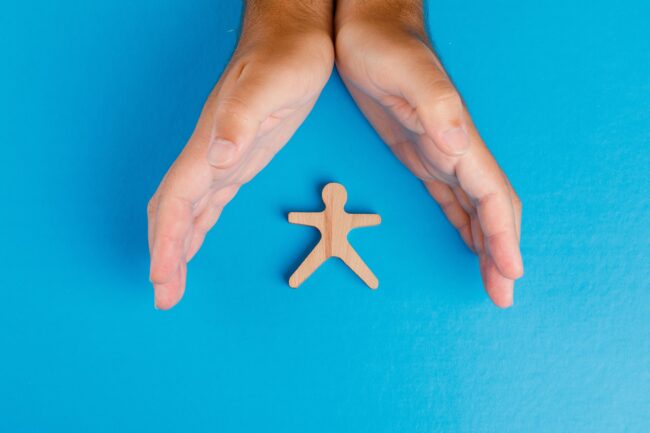 social-protection-concept-blue-table-flat-lay-hands-taking-care-wooden-human-figure-min-min smart locker welfare